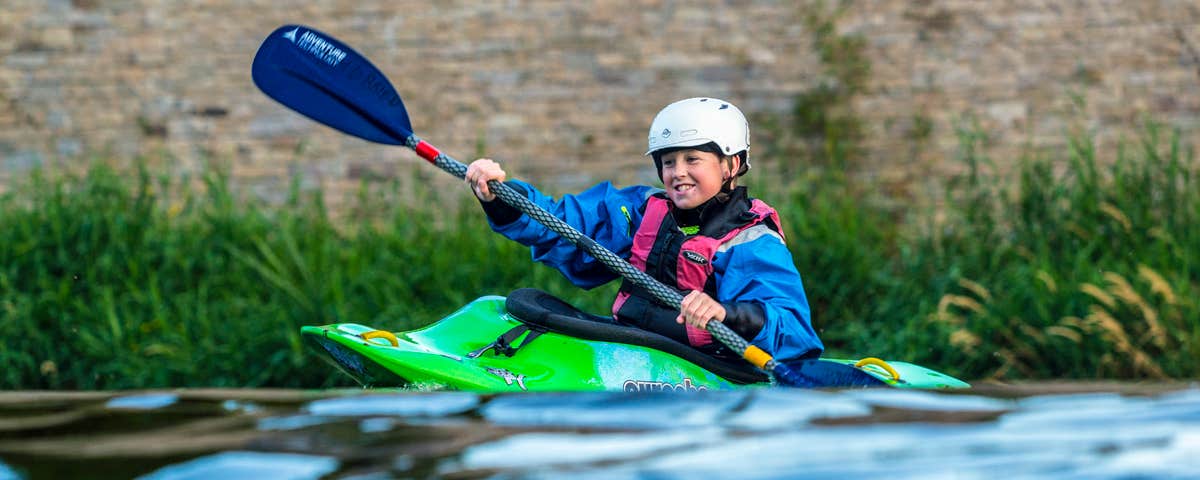 A young person kayaking on the river along the Suir Blueway