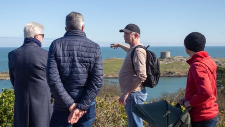 People and their tour guide looking at a coastal view