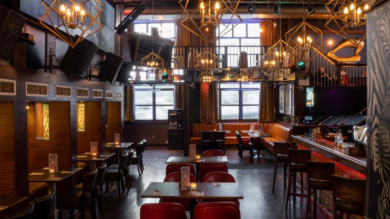 Interior of a pub with booths and chairs at the counter and tables and chairs in the middle