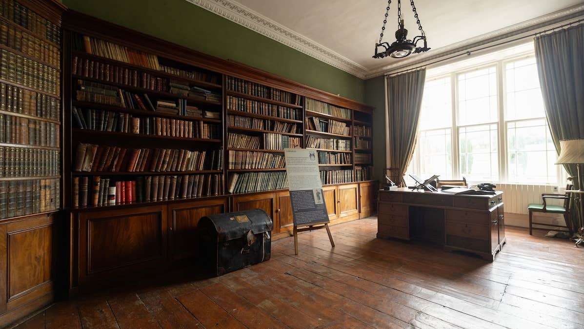 View of a library with wooden book cases and a desk