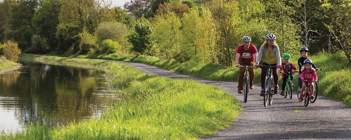 A family of five cycling along the Royal Canal Greenway path