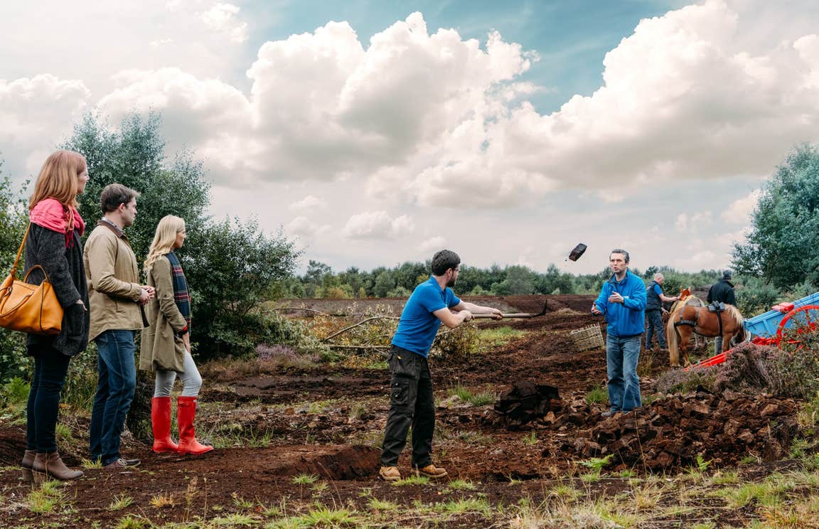 A group of people watching staff demonstrate activities at Lullymore Heritage Park, Co. Kildare