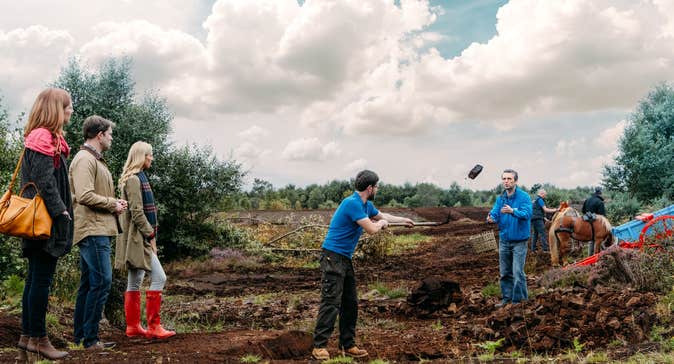 A group of people watching staff demonstrate activities at Lullymore Heritage Park, Co. Kildare