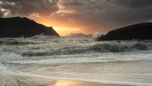 Image of waves on the beach at sunset.