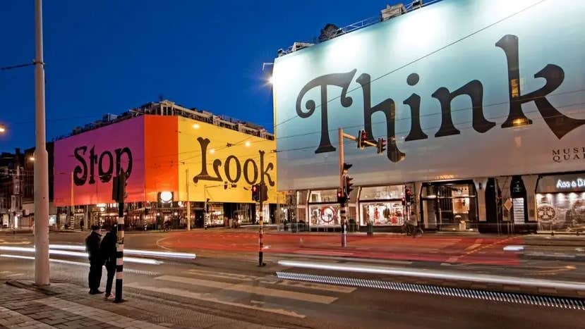 A series of buildings with coverings mentioning the words 'Stop', 'Look' and 'Think'.
