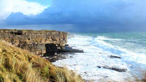 Image of waves crashing against cliff.