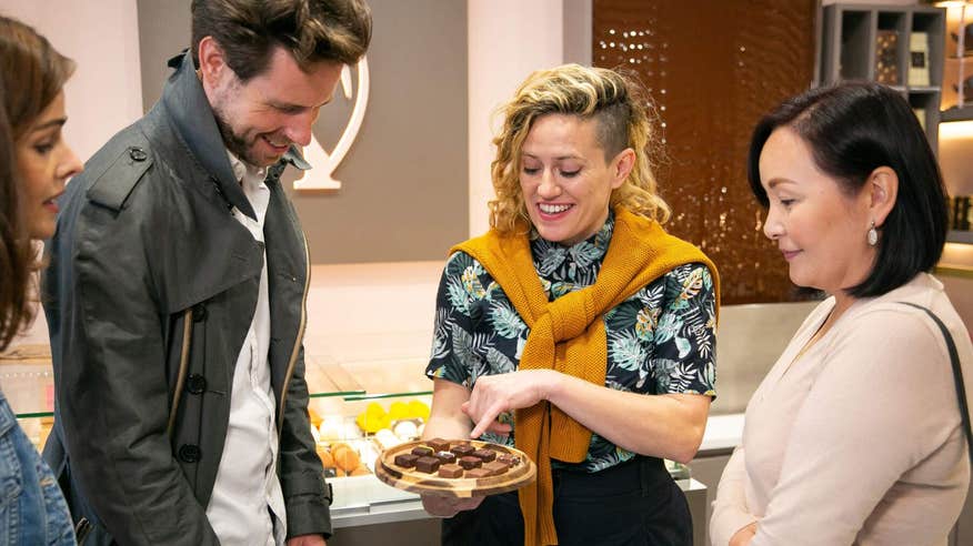 Tour guide showing a group of people different types of chocolates on a food tour in Galway.