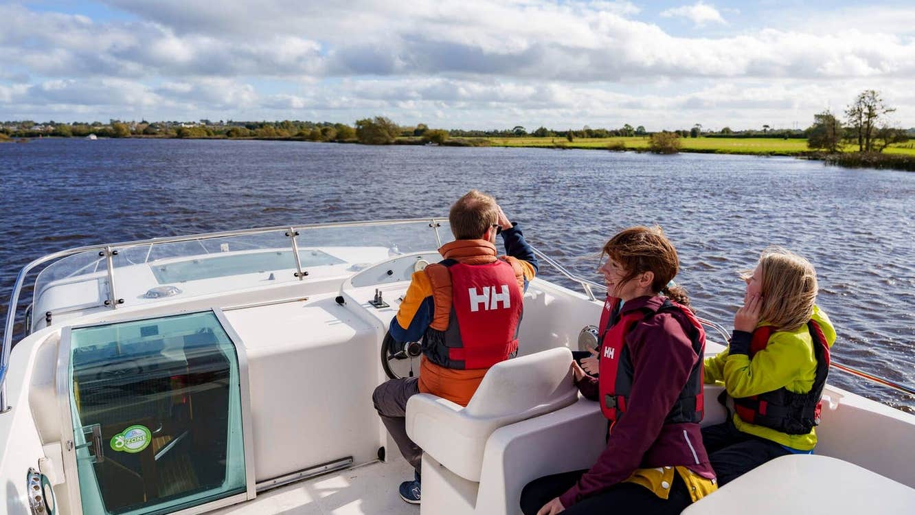 Three people on a cruiser on a river