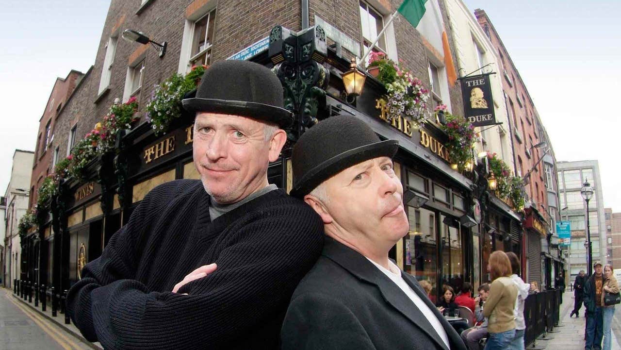 Two people in costume posing outside a pub