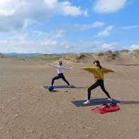 Two women doing yoga on Strandhill Beach in County Sligo, Ireland