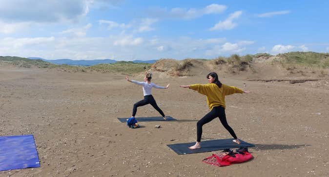 Two women doing yoga on Strandhill Beach in County Sligo, Ireland