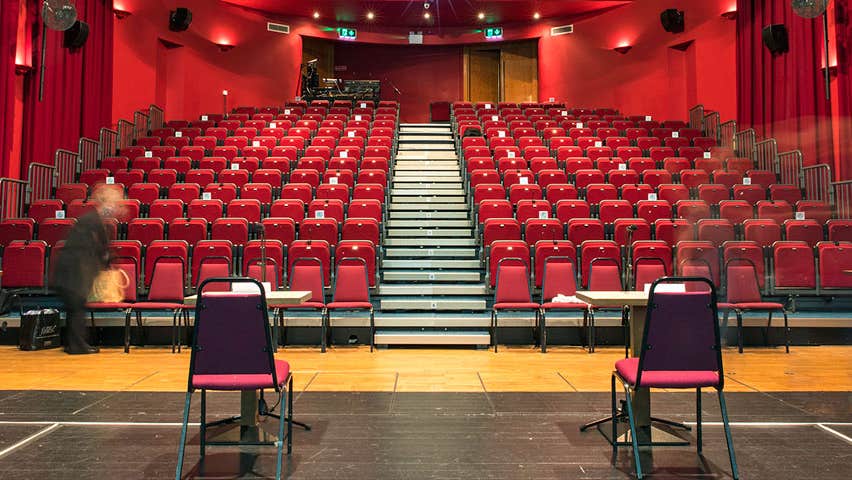 Interior of theatre at Dunamaise Arts Centre from stage facing read theatre style seating layout surrounded by red drapes