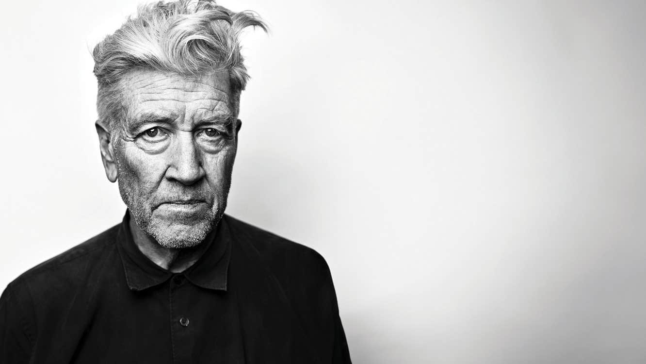 An elderly David Lynch against a blank wall.