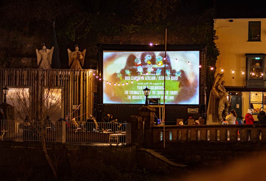 Outdoor screen in Kilkenny with an audience watching.