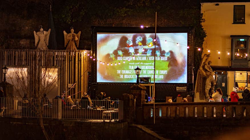 Outdoor screen in Kilkenny with an audience watching.