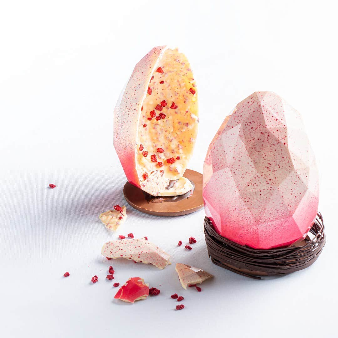 A pink and white chocolate Easter egg split in two made by Arcane Chocolate