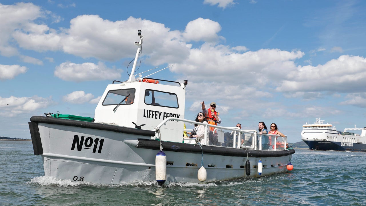 The Old Liffey Ferry number eleven on the water with people waving