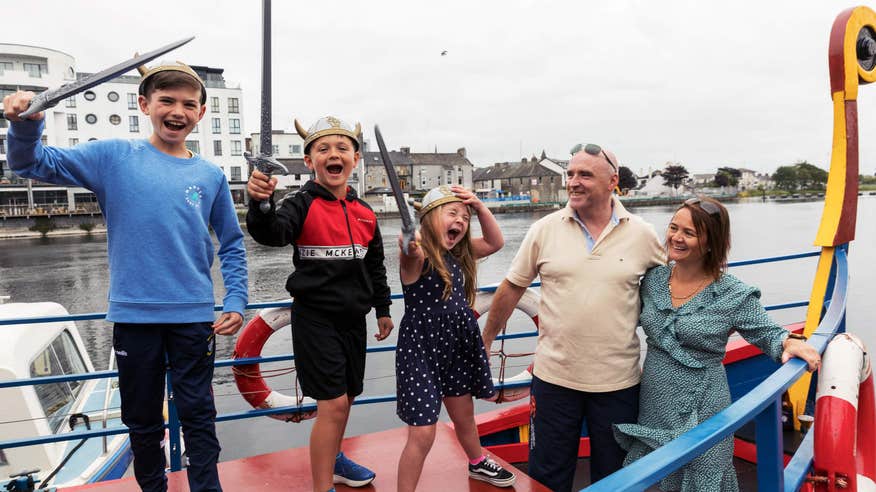 Family with three young kids holding swords on Viking Boat Tour in Athlone.