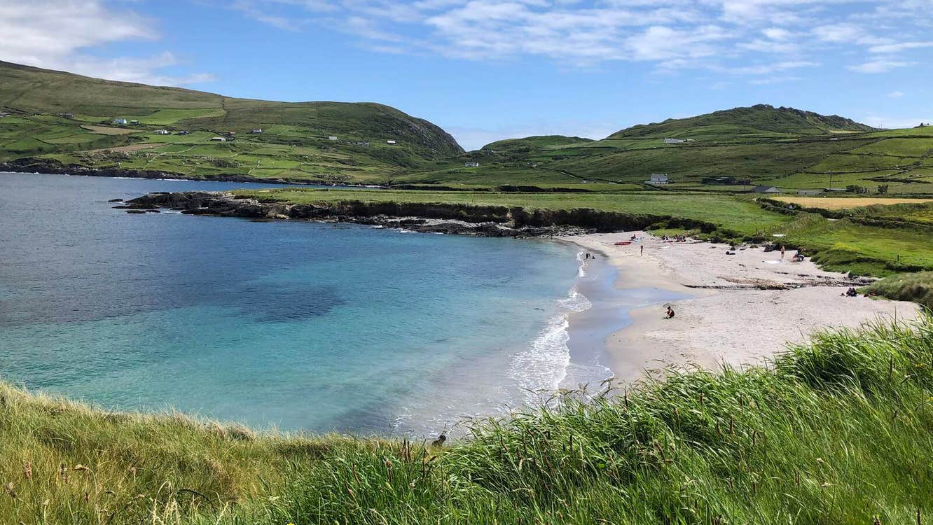 View towards a sandy beach with green hills in the background