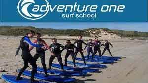 A group of people learning how to surf at Adventure One Surf School