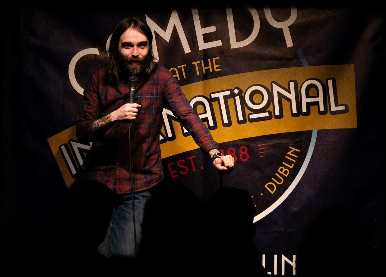 Stand up comedian performs on stage at Comedy at The International