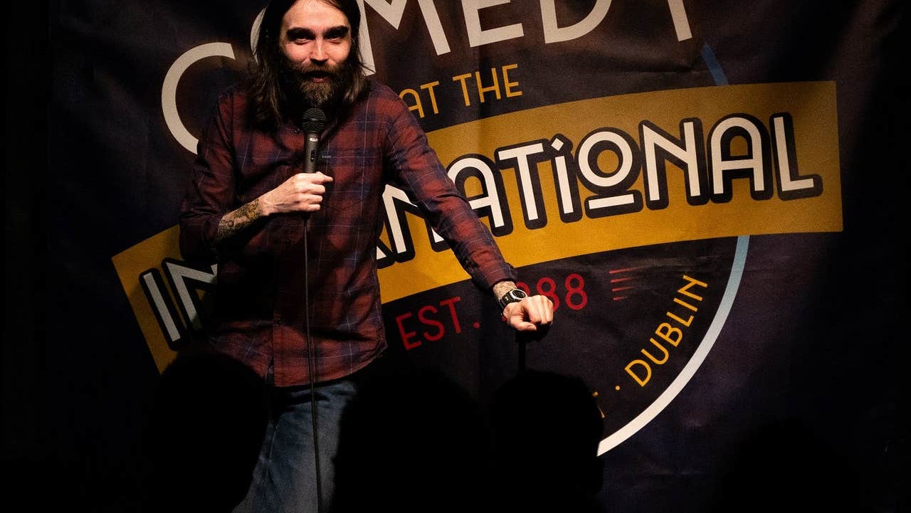 Stand up comedian performs on stage at Comedy at The International