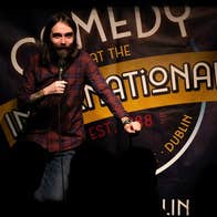 Stand up comedian performs on stage at Comedy at The International