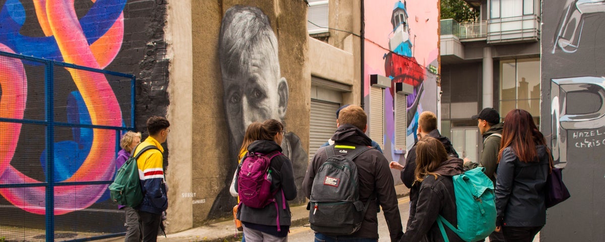 A tour group in Smithfield looking at some street art and graffiti