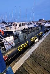 A RIB moored at a harbour with the company name on the side