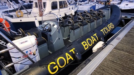 A RIB moored at a harbour with the company name on the side