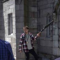 A guide holding an umbrella on tour talking to the group