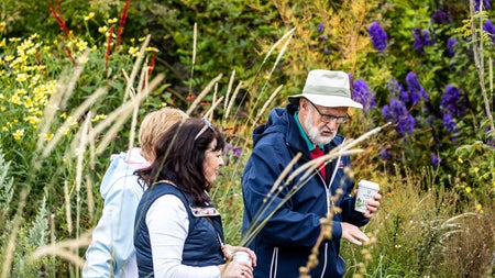 Three people walking in the gardens of Airfield Estate