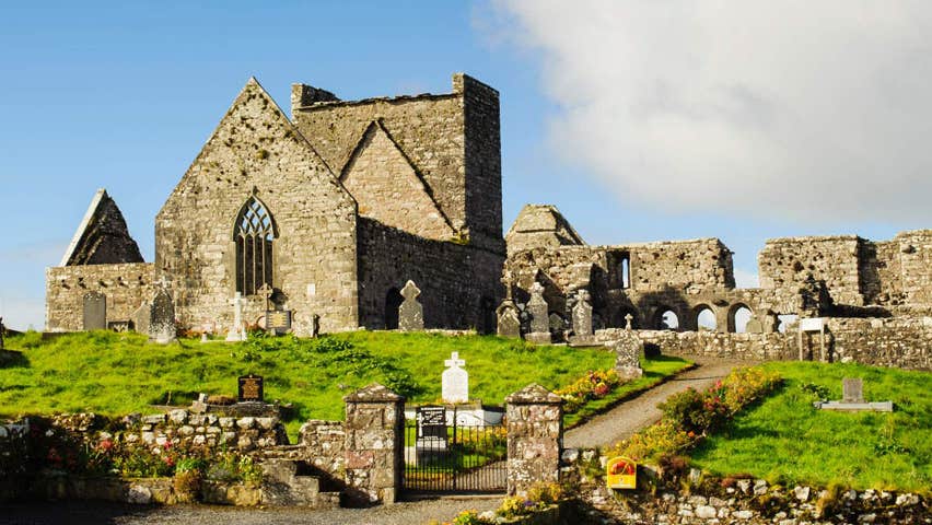 The ruins of an abbey overlooking a cemetery