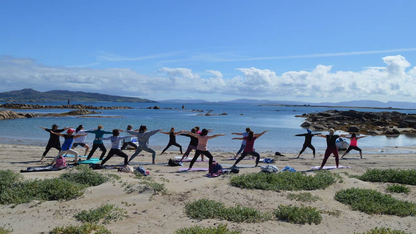 A group of people exercise on the beach