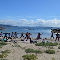 A group of people exercise on the beach