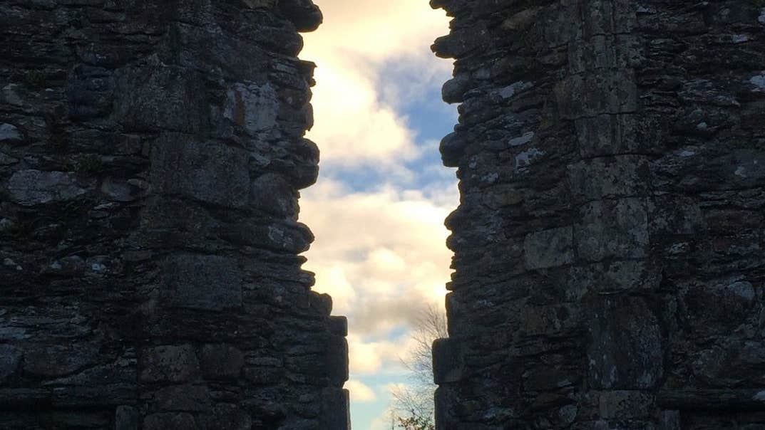 View through an old stone wall at Glendalough