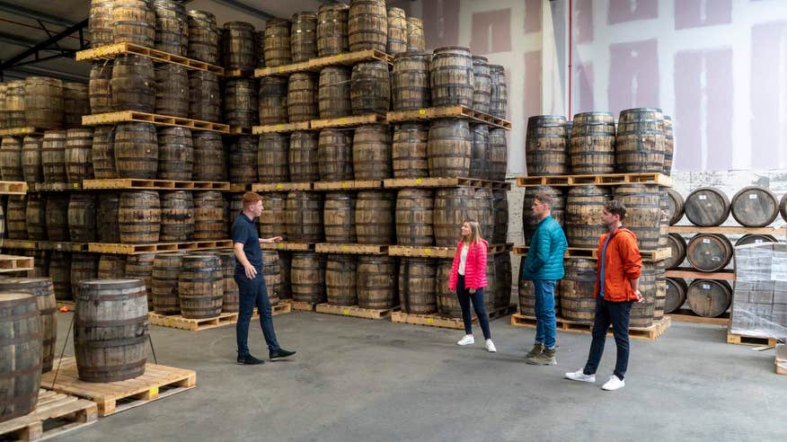 Inside the powerscourt distillery, picturing stacked barrels of whiskey.