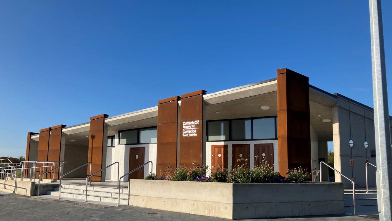 Side view of a modern building with railings and steps and a blue sky overhead