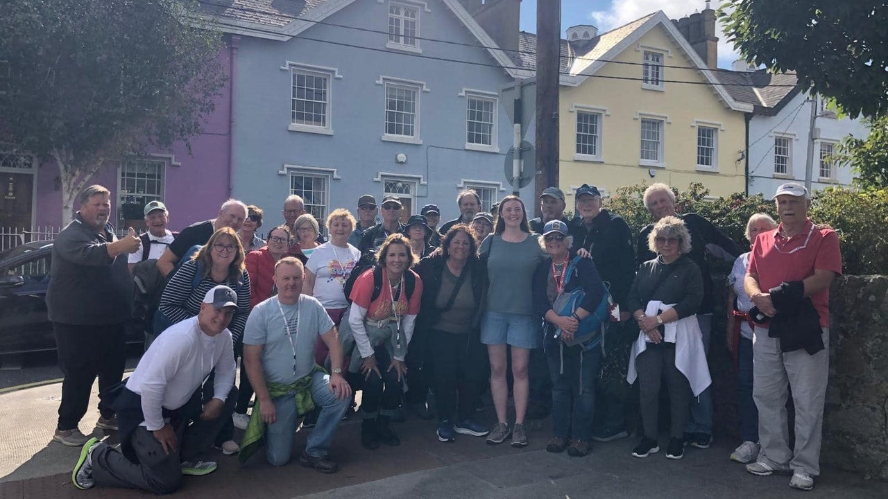 Group of people smiling for a photo in front of colourful buildings