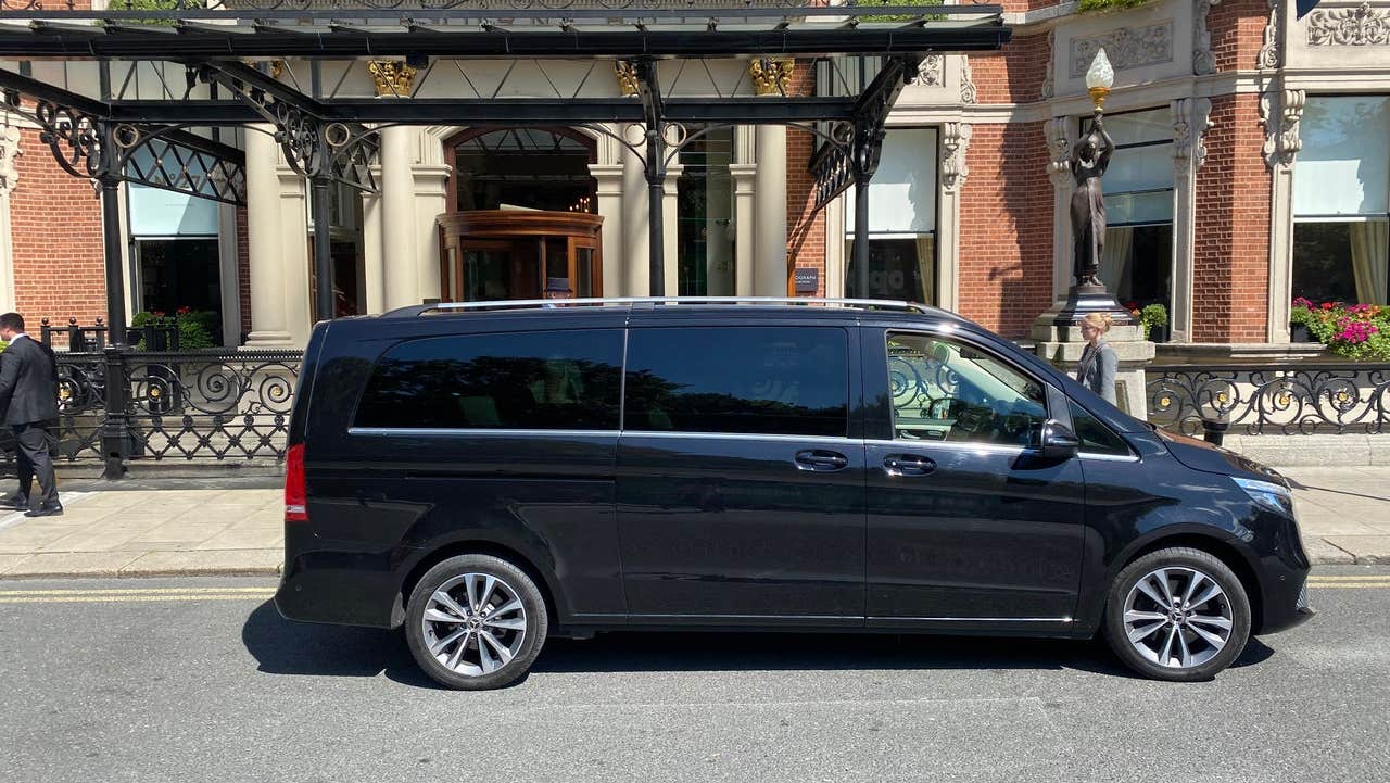 Luxury minivan parked at a hotel entrance