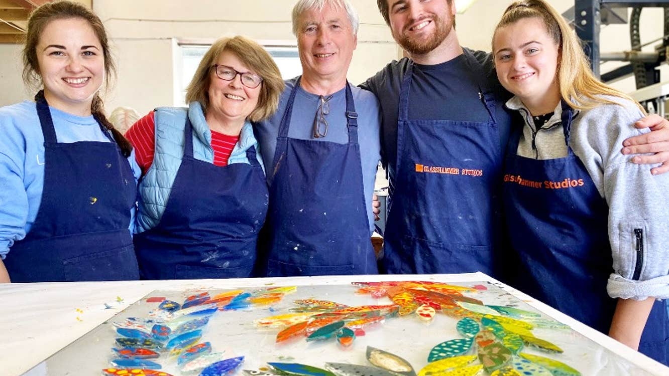 Glasshammer Studios view of five people next to their colourful painted glass project