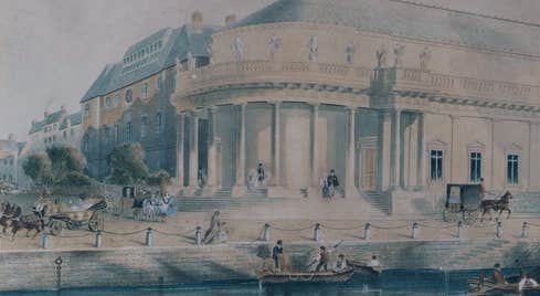 An old drawing showing the Crawford Art Gallery in a previous century with water and a dock outside and horses and carriages.