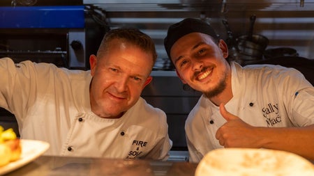 Two smiling chefs in a kitchen