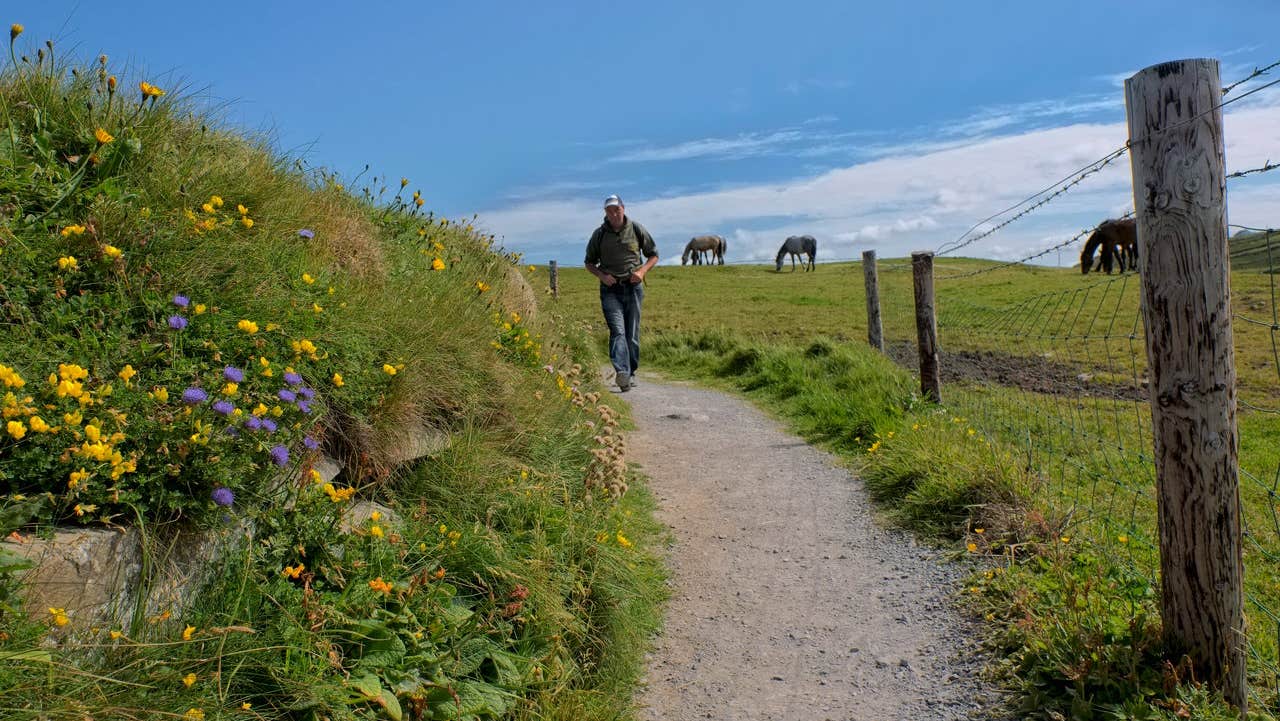 A man walking along a country side path