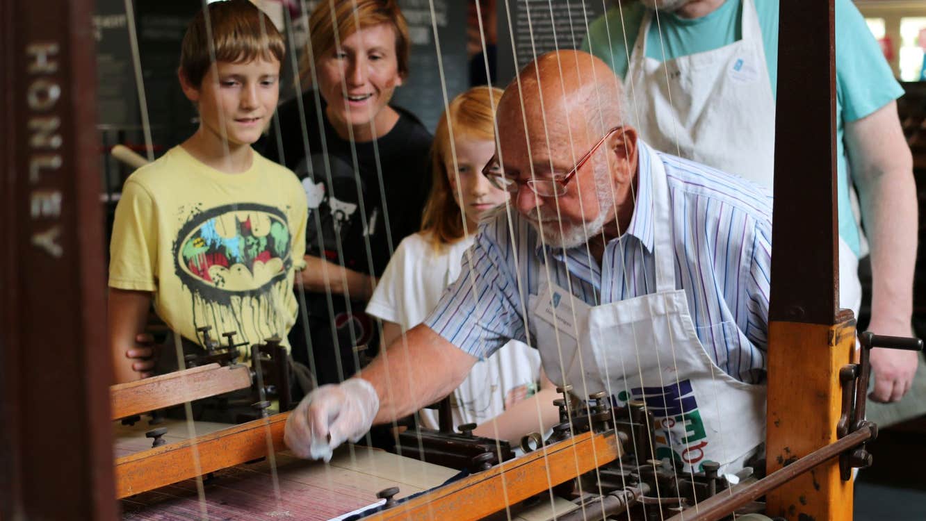 Science Demo Day at National Print Museum - a man demonstrating an old machine to onlooking children.