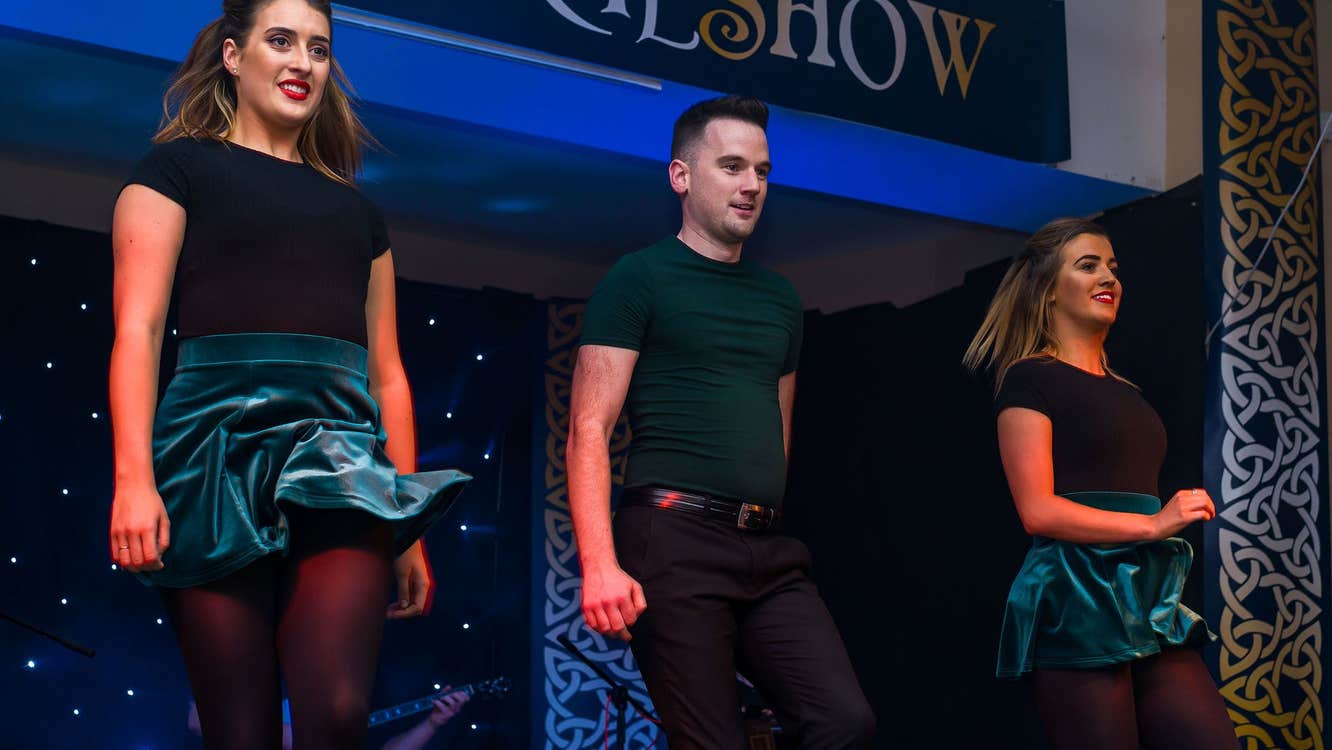 Three people in a line dancing on a stage