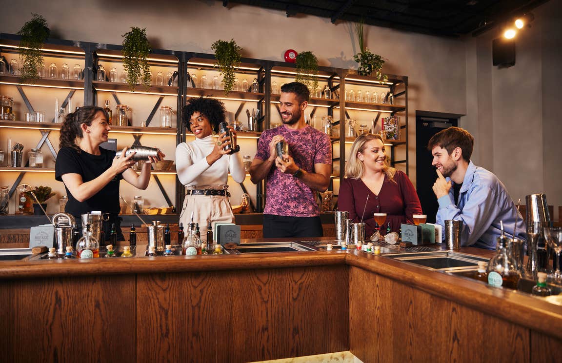 Four adults enjoying a whiskey cocktail making class at Roe & Co Distillery, Dublin.