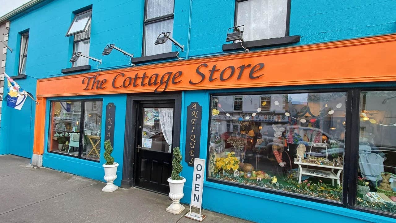 Colourful exterior of a shop with antiques displayed at the windows