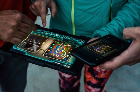 A close up of children solving a clue on a hand held device