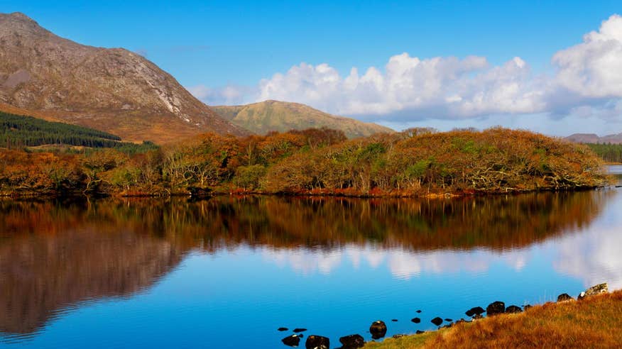 Golden hills reflecting on calm water at Lough Inagh, Galway